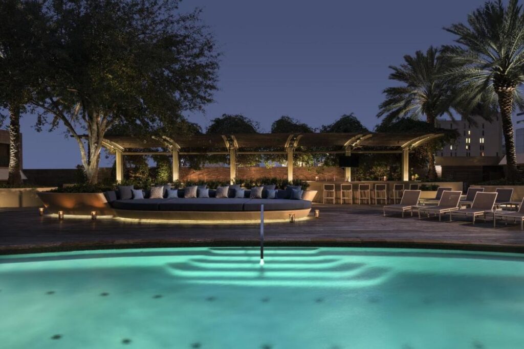 the rooftop outdoor pool and lounge at the Four Seasons Houston Hotel are lit up at night