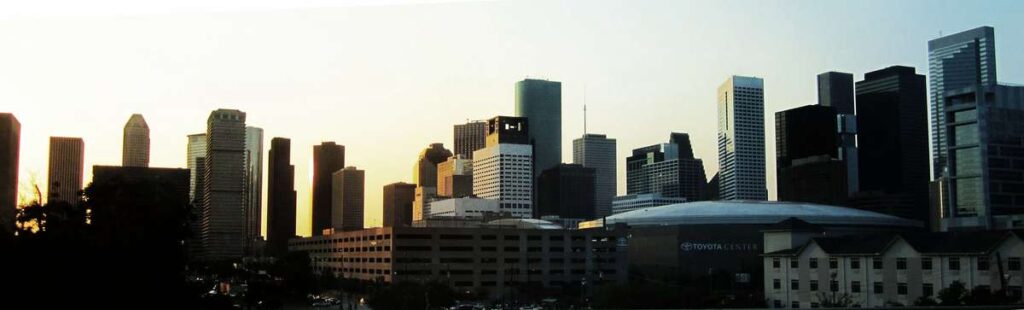 The Toyota Center sits in front of tall office towers in downtown Houston, TX