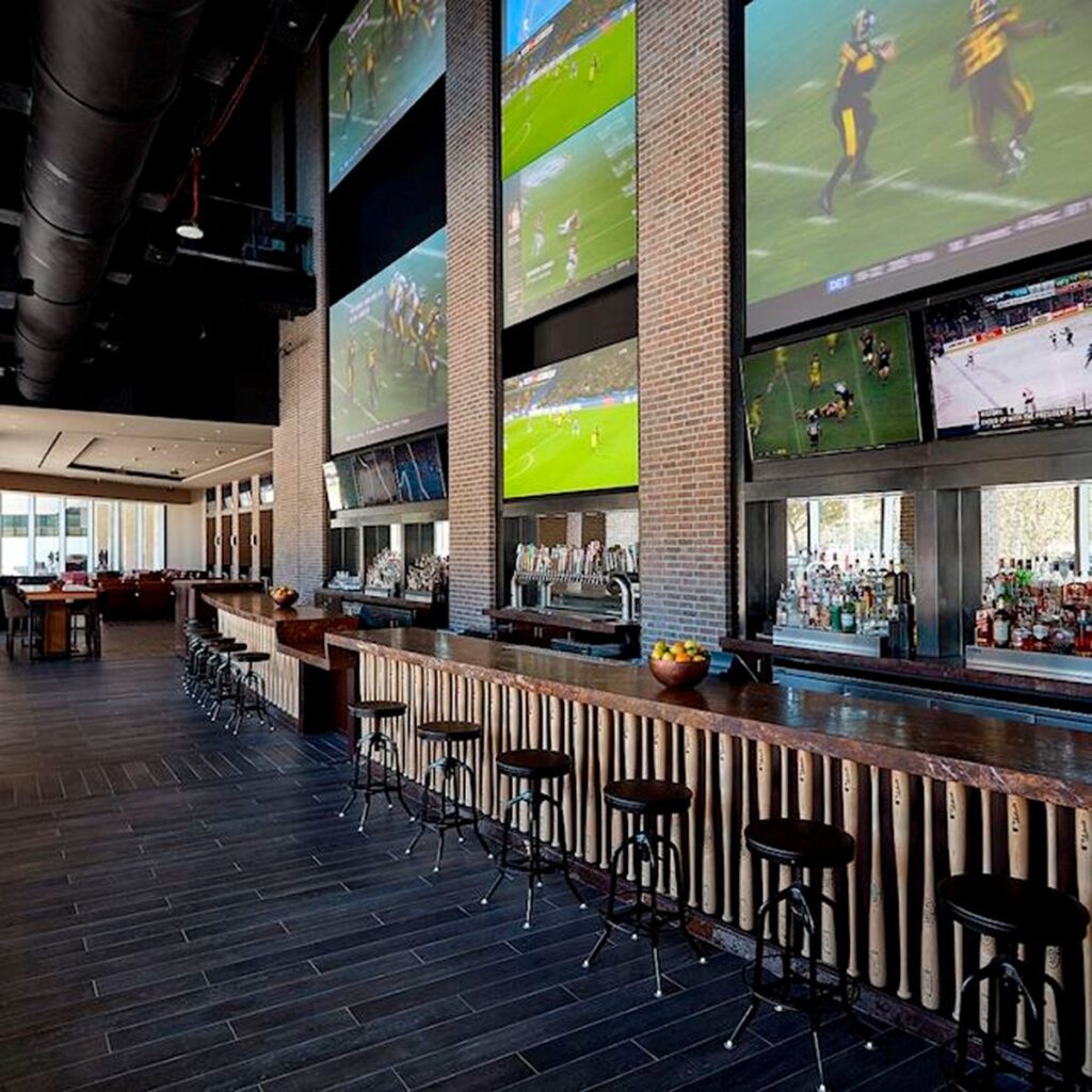 A wall of TV screens play sporting events at Biggios - a popular sports bar near the Toyota Center, Houston, TX