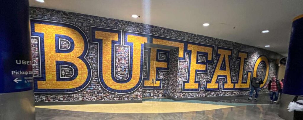 a mural inside the KeyBank Center with many small photographs and a large "Buffalo"