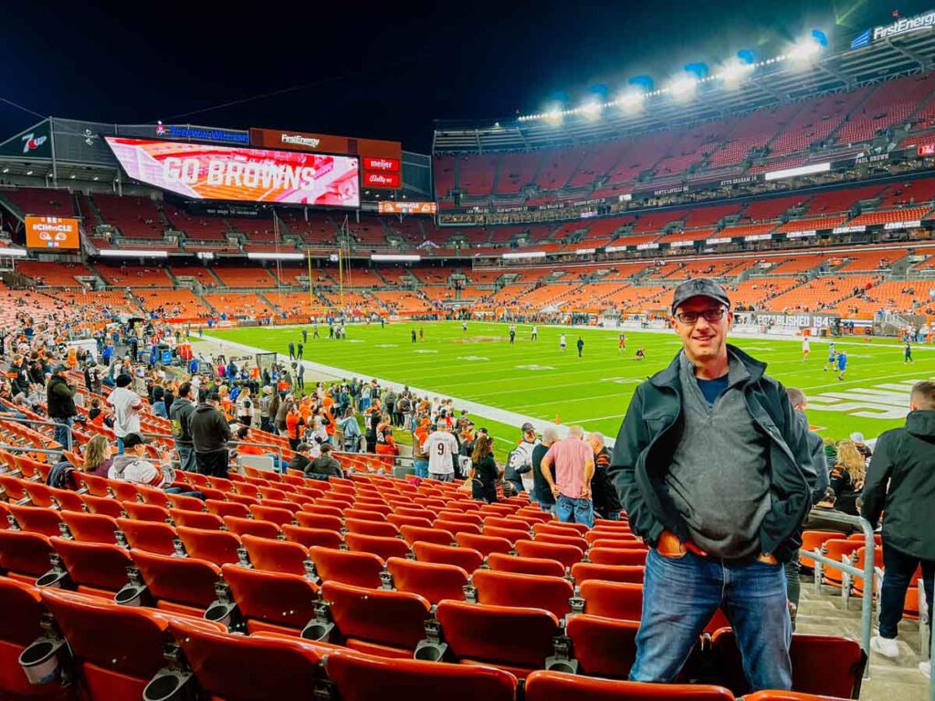 Dan Brewer, of Ultimate Sports Road Trip, poses for a photo in the lower bowl corner section of Cleveland Browns Stadium.
