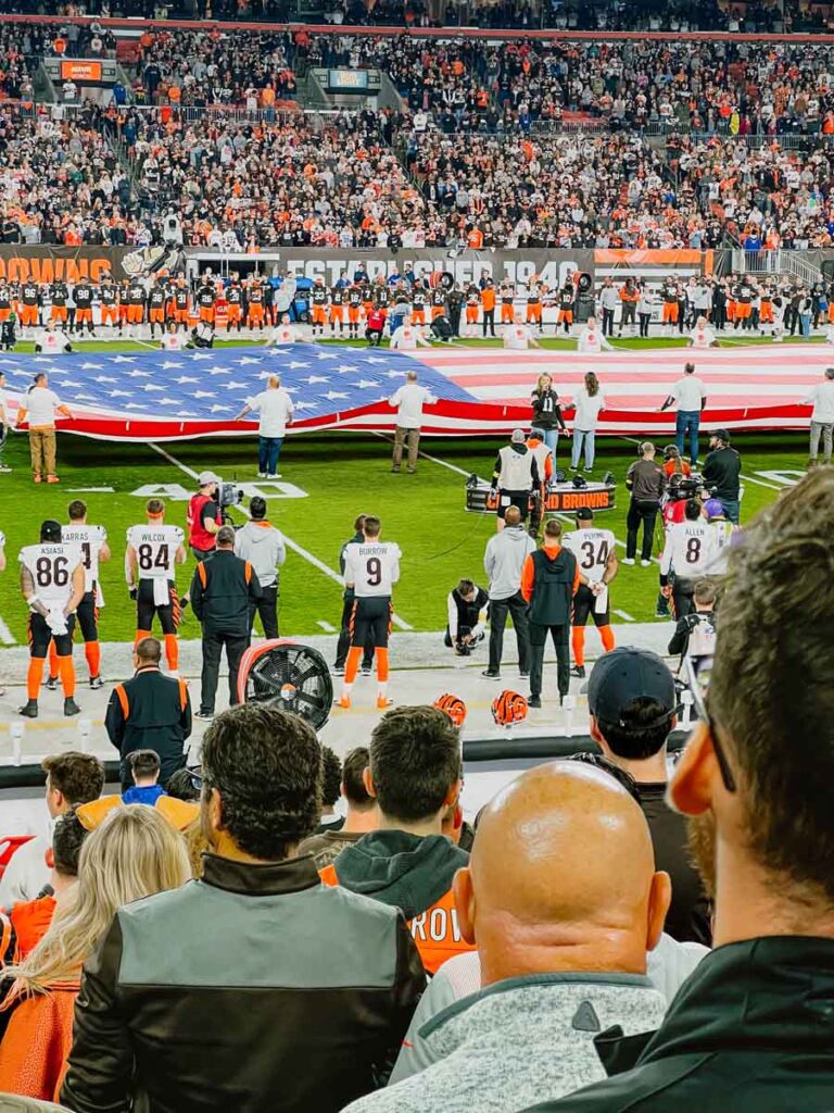 The US flag is displayed midfield during the national anthem at Cleveland Browns Stadium.