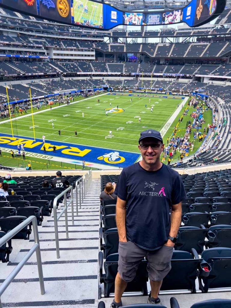 Dan Brewer, owner of UltimateSportsRoadTrip.com, stands at his seats in SoFi Stadium prior to an LA Rams game.