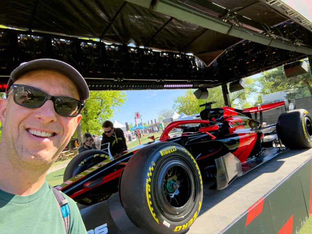 Dan Brewer, owner of Ultimate Sports Road Trip, poses with a Formula 1 car in the Fan Zone at the Montreal Grand Prix.