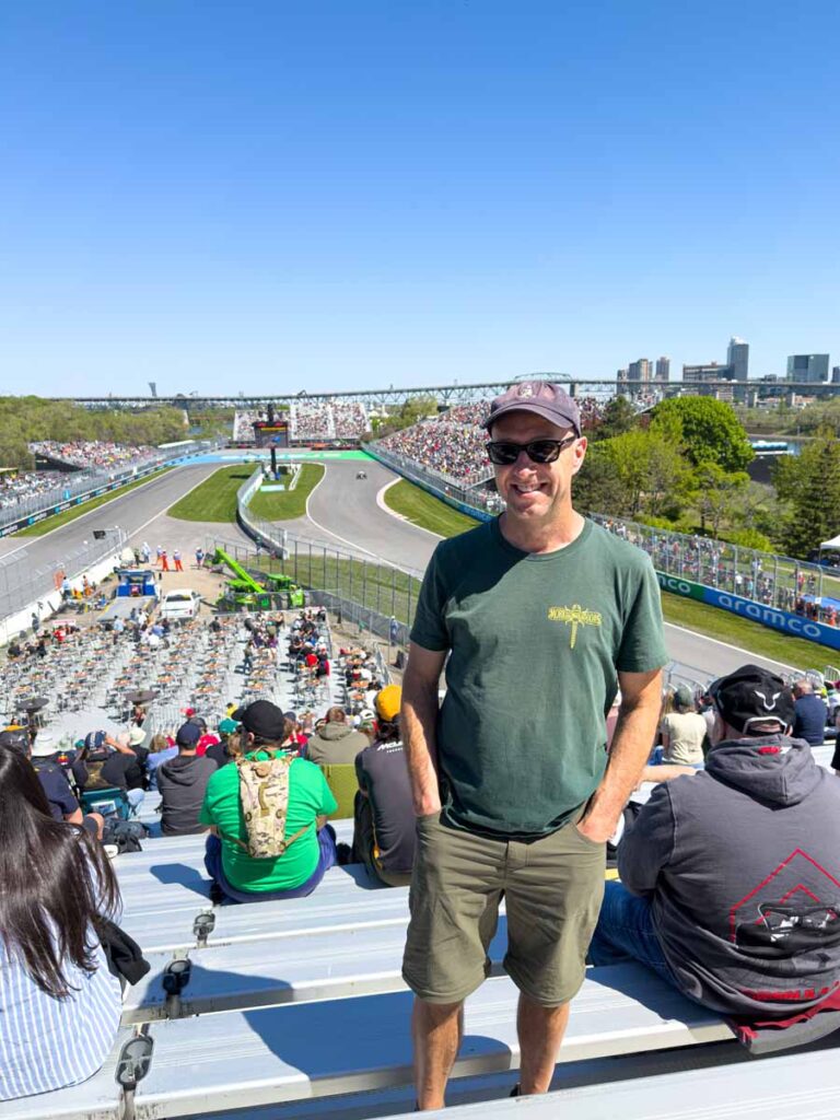 Dan Brewer, owner of Ultimate Sports Road Trip, wears shorts, t-shirt and a baseball cap to the Montreal Grand Prix on a sunny day in May.